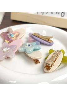 Close-up of star-shaped crystal rhinestones on colorful acetate flower hair clips