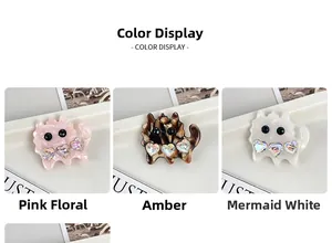 Detailed view of three cat-shaped hair clips in floral pink, amber, and pearlescent white