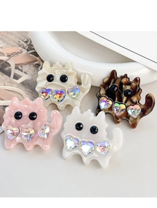 Macro shot of colorful cat acetate hair clips with heart rhinestones on ceramic plate