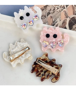 Detail of four colorful acetate cat hair clips with sparkling rhinestone heart accents