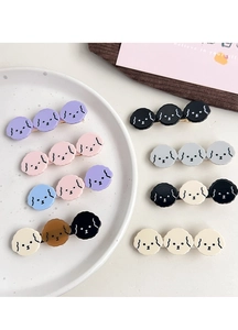 Close-up of cute cartoon poodle hair clips in eight different colors on a white plate