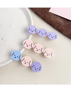 Detailed close-up of cute cartoon poodle hair clips in pink blue and purple colors