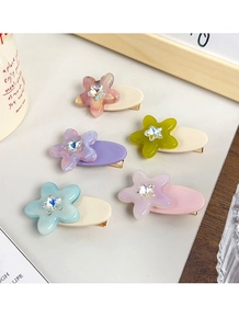Close-up of star hair clips with rhinestones and golden metal duckbill bases