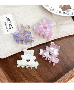 Détail de quatre pinces à cheveux ours colorées avec découpe en cœur en acétate