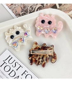 Detailed view of cat-shaped acetate hair clips with inlaid rhinestones and gold metal clips