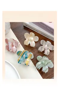 Set aus fünf floralen Haarklammern aus Acetat in Pastellfarben auf einem Tisch