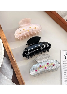 Détail des pinces à cheveux lune et étoile colorées en rose, noir et paillettes argent