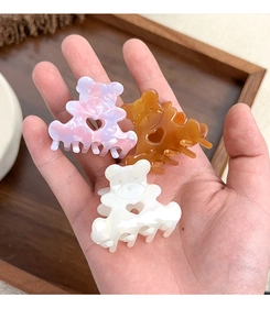 Lot de trois pinces à cheveux en forme d'ours mignon en acétate coloré dans la main