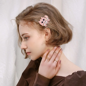 Cute pink monster hair clip with heart crystals worn on short hair side view