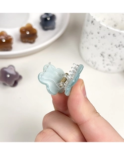 Détail de mini pinces à cheveux fleur en acétate avec strass et ressort métallique