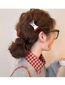 Close-up of a creative apple core claw clip with a blue bow worn on hair by a model