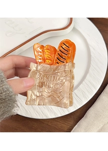 Detailed close-up of amber baguette-shaped acetate hair claw with Baking Over text