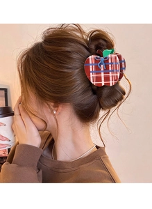 Detail of red and blue plaid apple-shaped hair claw clip with bow on model