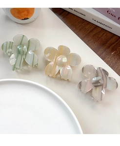 Drei Blumengreifklammern aus Acetat in Pastelltönen: Grün, Orange und Lila gestreift