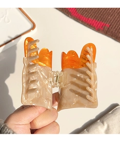 Macro detail of French baguette acetate hair claw clip with realistic paper bag design