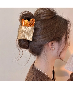 Creative baguette bread resin hair claw clip shown in a stylish updo on a female model