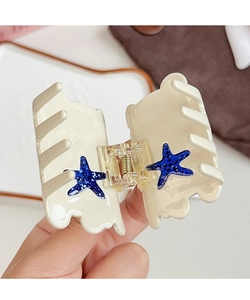 Close-up of cream hair claw with blue glitter starfish detail and metal spring