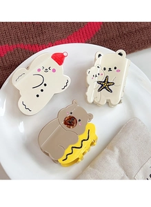 Close-up of three cute cartoon bear and character hair claws on a white ceramic plate