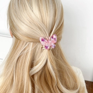Élastique à cheveux papillon en acétate rose et violet sur cheveux blonds