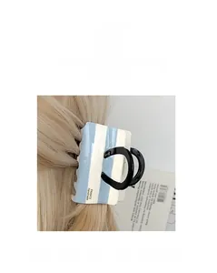 Detail of blue and white striped claw clip with Handmade France text on hair