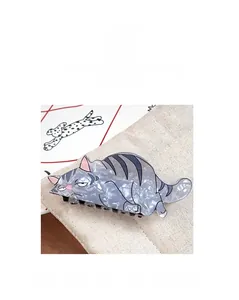 Close-up of grey cartoon cat hair claw clip with pearlescent finish and funny face expression