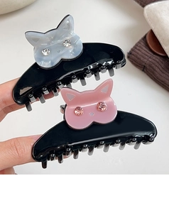 Détail de pinces à cheveux chat en résine brillante avec yeux en strass étincelants