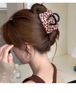 Detail of pink leopard print rectangular hair claw clip worn for an elegant updo