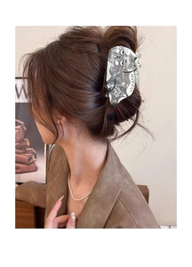 Detail view of a cute marble white cat hair claw clip worn in an elegant hairstyle