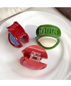 Détail de pinces à cheveux boutons colorées dans un plat en céramique et tissu