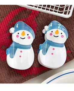 Detailansicht von zwei süßen Schneemann-Haarklammern mit blauen Schals auf Strick
