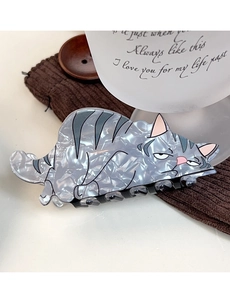 Detail showing marble texture acetate cat hair claw clip on a cozy knit background
