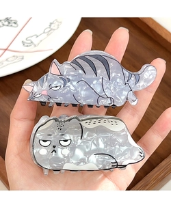Close-up of cute cartoon cat hair claw clips with marble texture on wooden tray