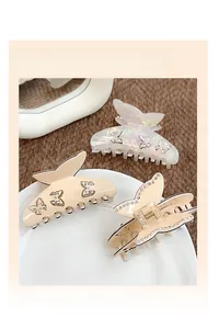 Détail de pinces à cheveux papillon élégantes avec strass et finition nacrée