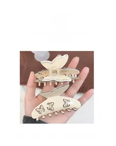 Gros plan de pinces à cheveux papillon en acétate beige avec détails en strass brillants