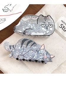 Detail of cute cat-shaped acetate hair claws with marble texture on canvas bag