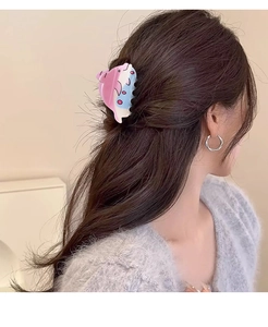 Gros plan d'une pince à cheveux dauphin dégradé rose et bleu portée par un mannequin de profil