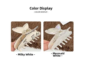 Détail des pinces à cheveux papillon en crème mate et blanc nacré avec des strass fins