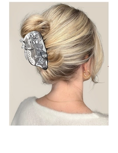 Detail view of the cute grey cat hair claw clip styled on a low blonde ponytail