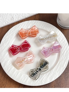 Detailed close-up of colorful resin bow hair clips with marble texture and glitter finish