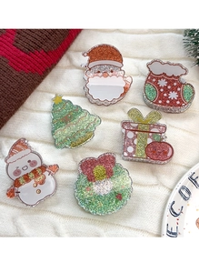 Makroaufnahme von glitzernden Acryl-Weihnachtsnadeln mit Weihnachtsmann und Baum