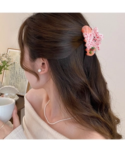 Pince à cheveux étoile de mer à motif floral montrée sur une coiffure demi-queue