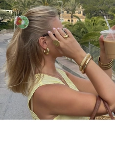 Details von goldenen Armbändern und festlichen Haarspangen an einem Urlaubsmodel