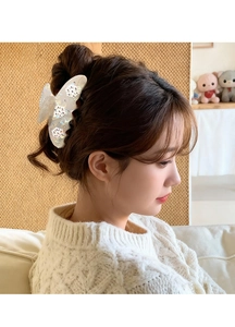 Detail view of white pearl acetate hair claw clip with elegant rhinestone flower motifs