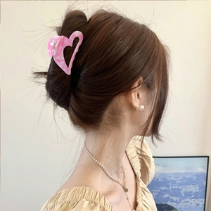 Eleganter Haarklammer aus rosa Acetat in Herzform für Dutt-Frisuren am Modell