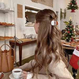 Eleganter Weihnachts Haarklammer mit festlichem Design, getragen in einem warmen Café