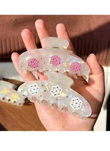 Detailed macro view of acetate snowflake hair claws with sparkling rhinestones and pearly finish