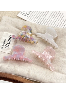 Detalle de cuatro pinzas para el cabello de acetato con patrones jaspeados y florales