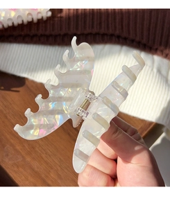 Detailed view of an iridescent butterfly hair claw clip with a shimmering colorful finish