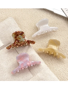 Detalle de cuatro pinzas para el cabello de acetato en perla, carey, ámbar y mármol