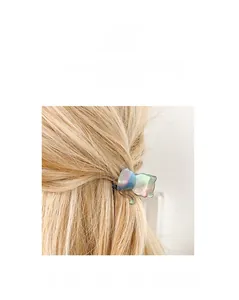 Detail of a gradient acetate cat hair claw clip worn on blonde hair for daily styling